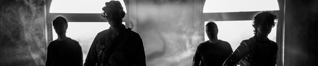 a group of young men standing in front of a window